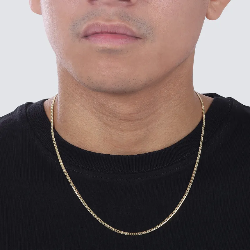 Man wearing a solid gold Miami Cuban link chain, 14k and 18k gold, made in Italy