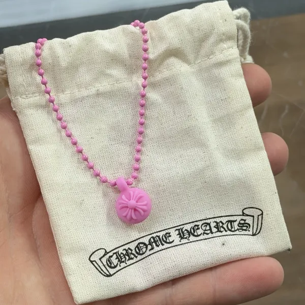 Pink Chrome Hearts silicone bead necklace with its dust bag, held at the counter for authentication