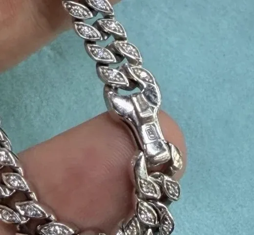 Close-up of a stamped box clasp on a pavé diamond Cuban link bracelet