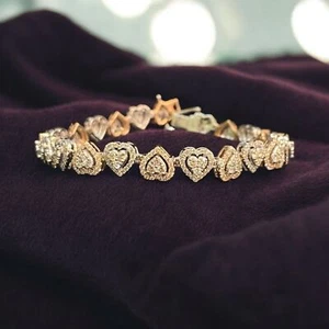 Two-tone gold bracelet of heart-shaped links set with small diamonds on purple velvet