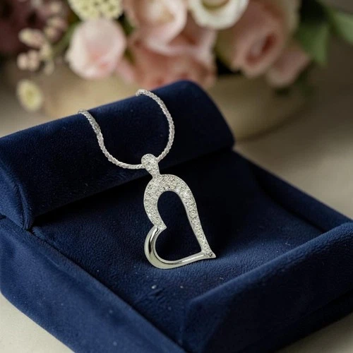 Pavé diamond open heart pendant on a rope chain displayed on a navy velvet jewelry box