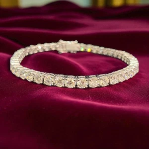 Diamond tennis bracelet with a single row of round stones and a box clasp on red velvet