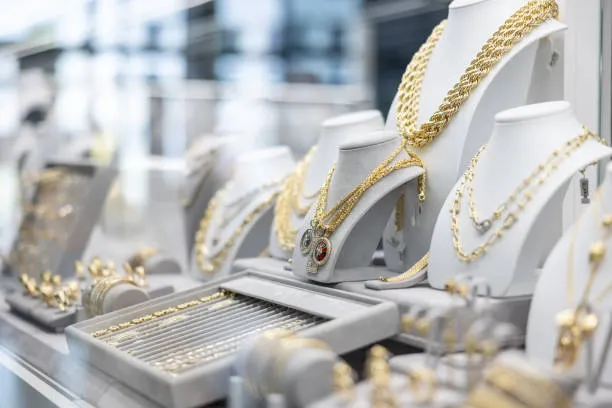 Diamond rings and gold necklaces displayed in a luxury jewelry store window case