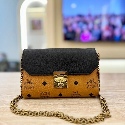 MCM cognac crossbody with a black leather flap and gold chain