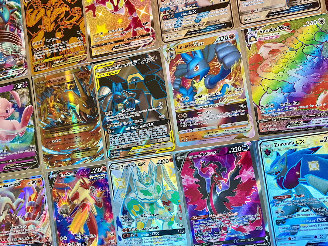 Collection of rare and holographic Pokémon trading cards including VMAX and GX cards