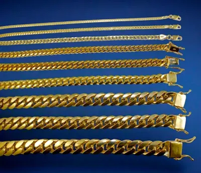 Row of solid gold Cuban link bracelets in graduated widths on a blue background