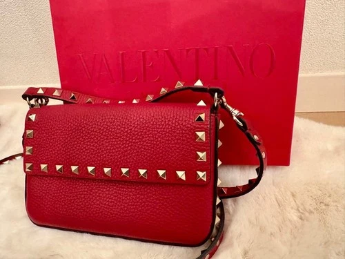 Red Valentino studded crossbody bag with its Valentino shopping bag