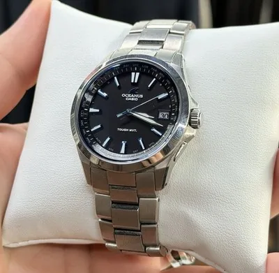 Stainless steel Casio Oceanus watch with a black dial on a white display pillow